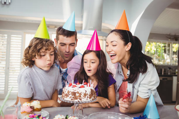 誕生日のケーキの上の蝋燭を吹く陽気な子供たち - cake birthday candle blowing ストックフォトと画像