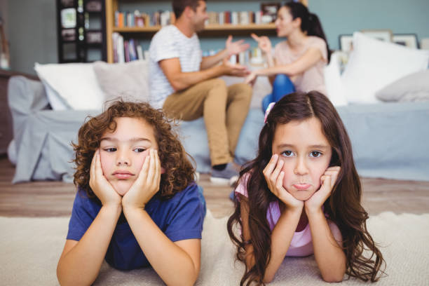 istock Sad siblings lying on carpet while parents sitting in background 699749094