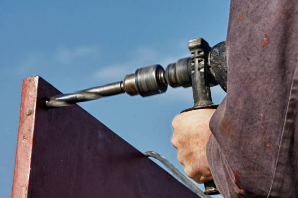 istock Drilling a hole in a metal plate by a drill 699749246