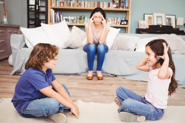 istock Children playing while tensed mother sitting on sofa 699753986