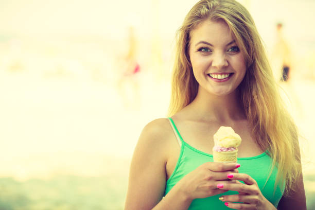 Diet, food, sweets, summer pleasures concept. Happy woman woman holding ice cream about to eat it.
