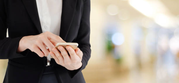 istock Business woman hands using smart phone over blur office with bokeh light background, banner, business on phone 699767236