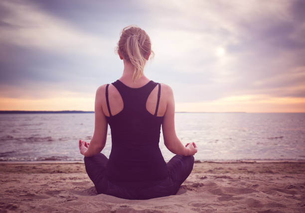 istock young woman sitting on the beach 699771546