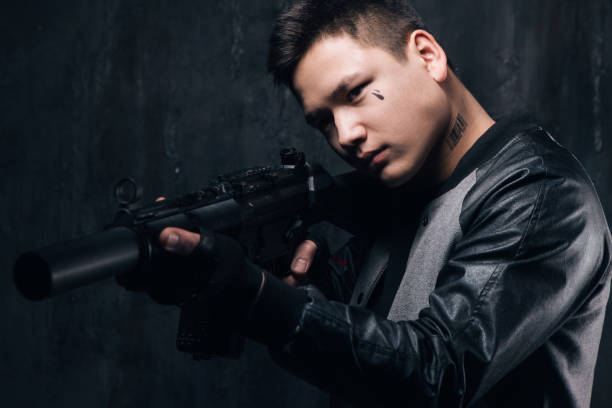 istock Sniper with tattoo on face and rifle close-up 699782750
