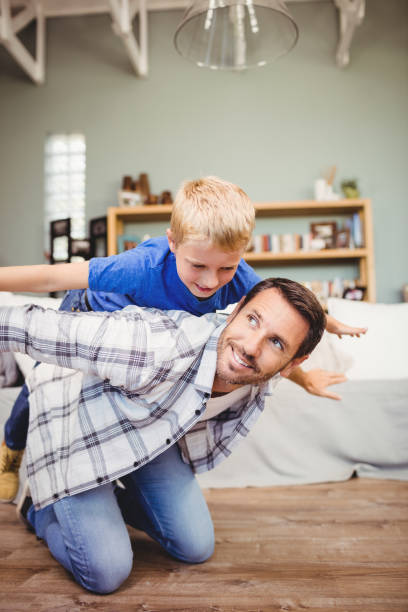 istock Happy father playing with son on hardwood floor 699783872