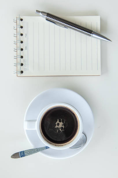 istock coffee,pen,notebook and pen  on wood table white background,top view 699784020