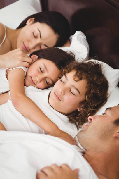istock Children sleeping with parents on bed 699787520