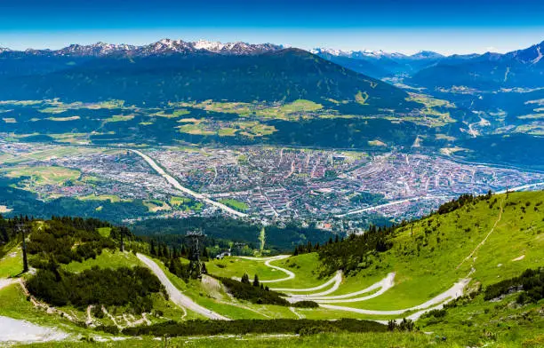 view from above of Innsbruck city with alpes mountain range, Natural path and Cable car take from Seegrube mountain