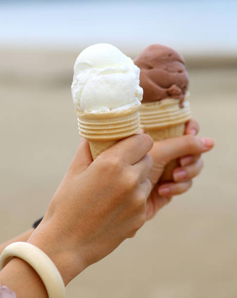 istock holding an ice cream at the seaside. 699794346