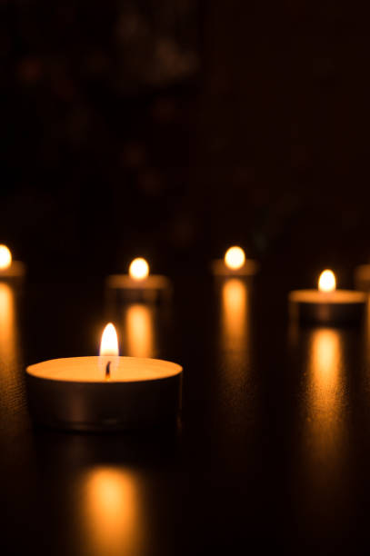 istock candle flame light at night with bokeh on dark background. Candles with light in a romantic decoration and defocused lights. Bokeh 699799456