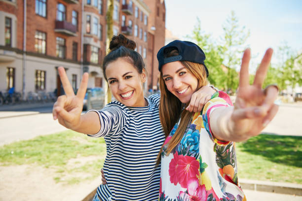 istock Two friends gesturing a V symbol with fingers 699803876