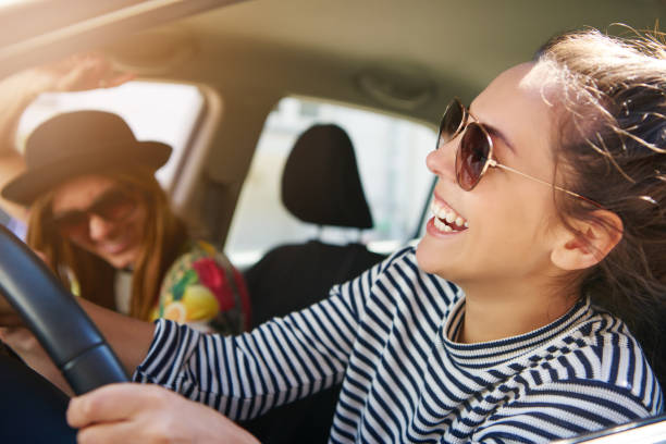istock Attractive woman laughing as she drives a car 699807010