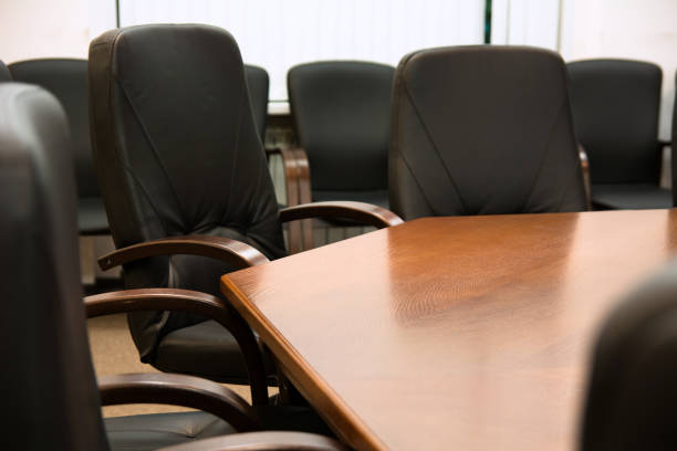 istock Black leather chairs around a wooden table 699807370