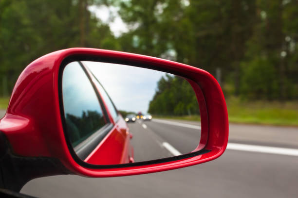 Highway Rear View View back to road through red side mirror at car rear view mirror stock pictures, royalty-free photos & images