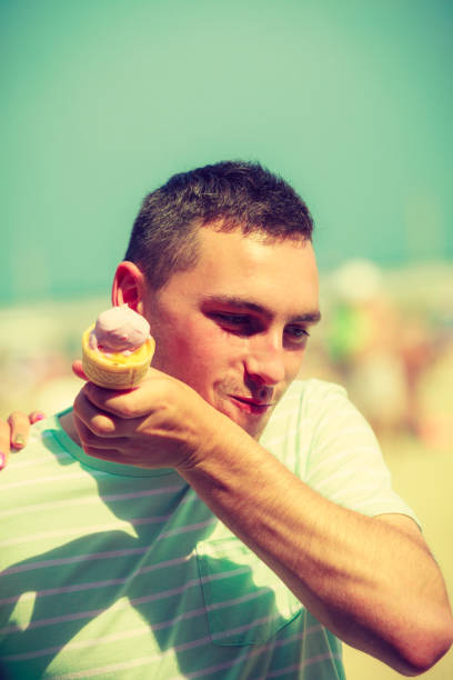istock Happy man eating ice cream on beach 699808434