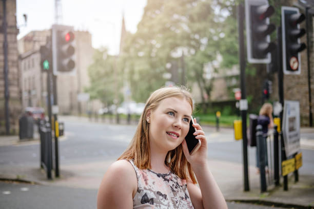 istock young woman on mobile phone in an urban setting. 699808750