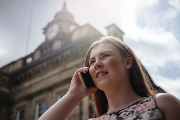 istock young woman on mobile phone, backlit in summer sunshine. 699808822