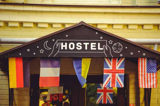 A painted red hostel sign on an old building in the city center A painted red hostel sign on an old building in the city center. Decorated with flags of different countries hostel photos stock pictures, royalty-free photos & images