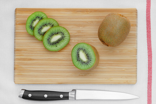 Sliced kiwi on a wooden board. Top view.