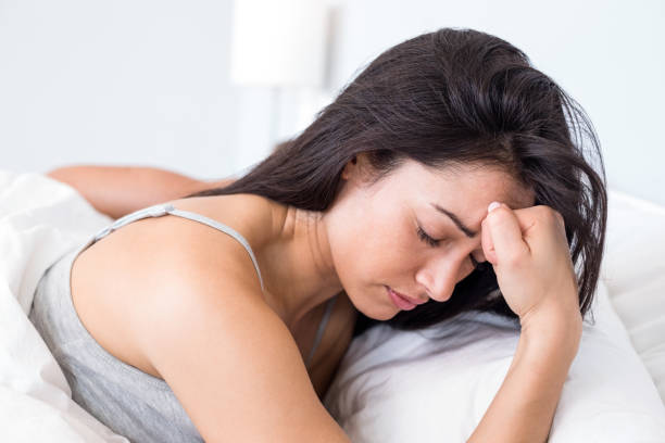istock Upset woman lying on bed 699857130