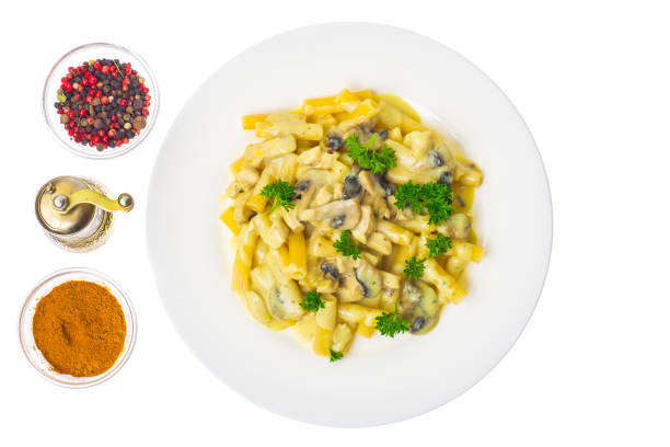 Macaroni with sauce, mushrooms, chicken on white plate. Studio Photo
