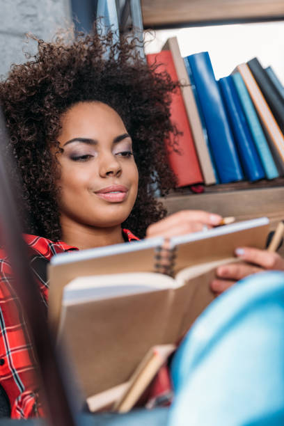 istock Attractive young african american student studying with books and textbooks 699860974