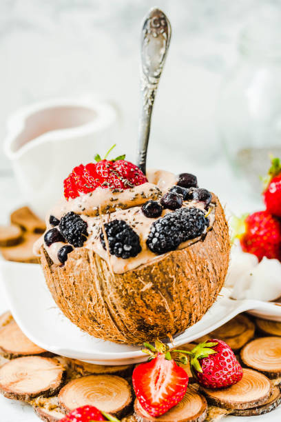 Chocolate vegan ice cream with berries on coconut cup.Summer food and healthy dessert concept stock photo