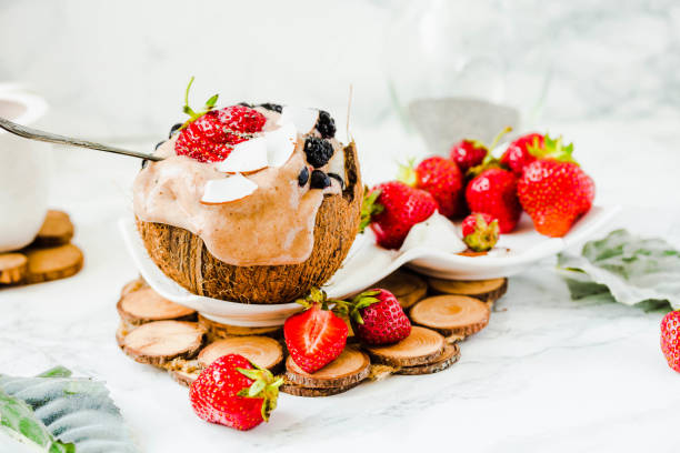 istock Melting chocolate ice cream with berries on coconut cup. Copy space.Marble background..Summer food and healthy dessert 699862882