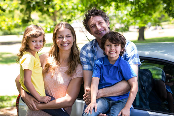 istock Smiling family in front of a car 699867894