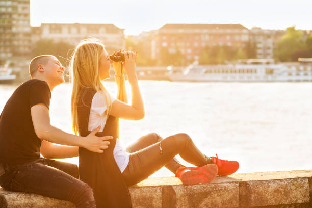 istock Cute girl and guy looking through binocular. 699868150