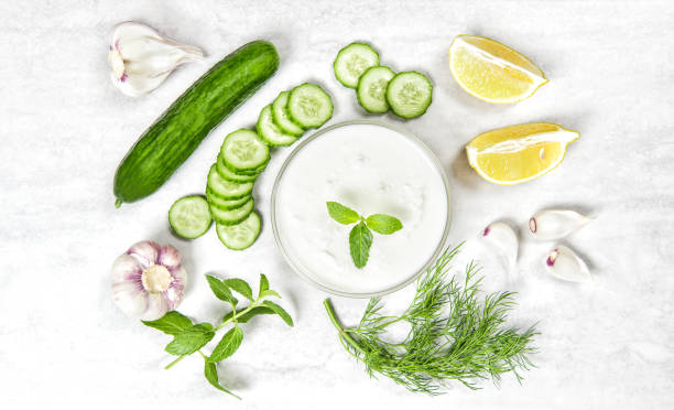 Tzatziki sauce ingredients. Yoghurt, mint dill herbs and cucumber. Food background