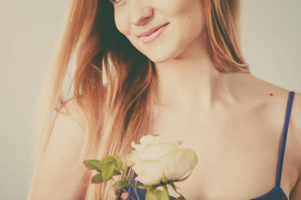 istock woman holding white rose 699883036
