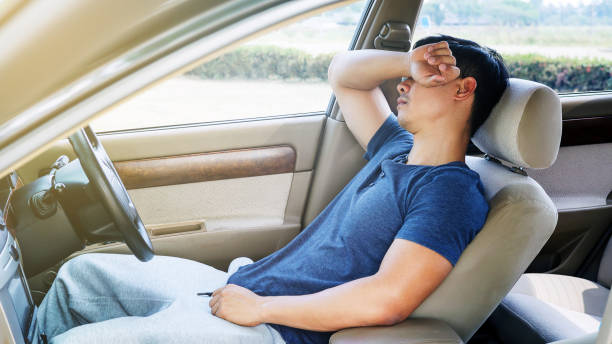 istock Asian young man sleeping in his car. 699885732