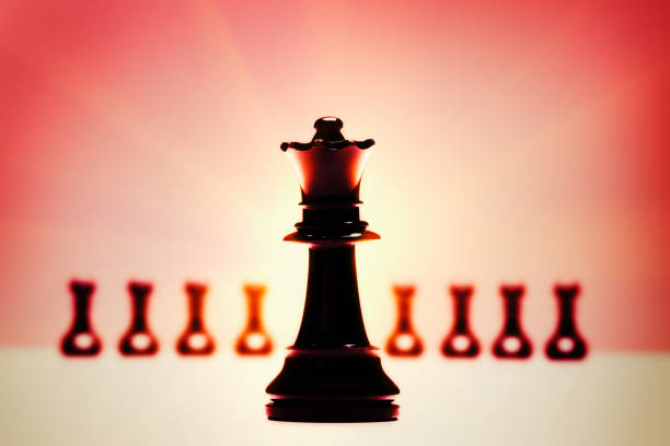 istock Chess queen with defocused pawns in glowing red light 699890732