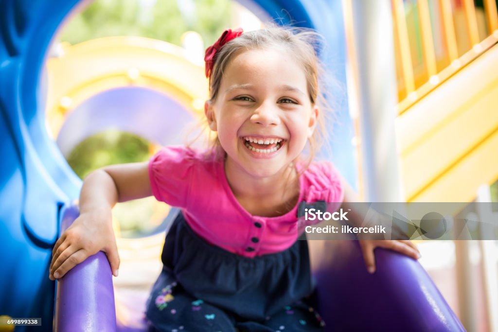 Niña jugando en el patio de recreo al aire libre en verano - Foto de stock de Niño libre de derechos