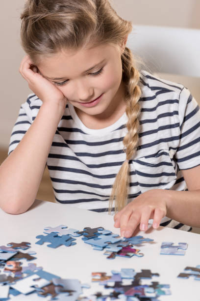 istock Girl playing puzzle on table at home 699939024