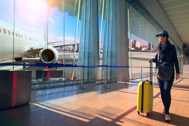 traveling woman and luggage walking in airport terminal and air plane flying outside - airplane air vehicle business travel passenger imagens e fotografias de stock