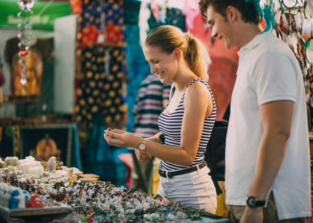 Buying Jewellery At Queen Victoria Market Young couple are looking at a jewellery stall in Queen Victoria Market, Australia. souvenir stock pictures, royalty-free photos & images