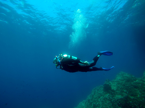 Scuba diver diving in sea water