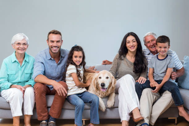 istock Family sitting on sofa with dog 700072484
