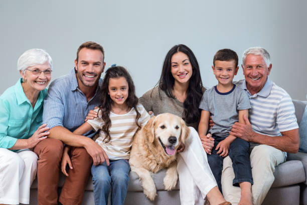 istock Family sitting on sofa with dog 700072546