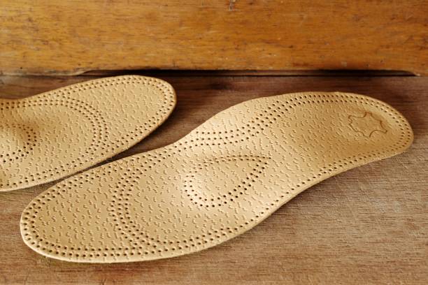 istock Orthopedic arch support made from leather on a wooden ground 700088930