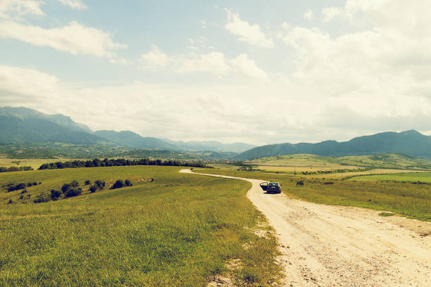Dirt track road with car in Carpathian Mountain Range Romania