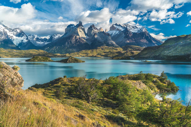 lac bleu sur un fond de montagnes enneigées et un ciel nuageux, torres del paine - chili photos et images de collection