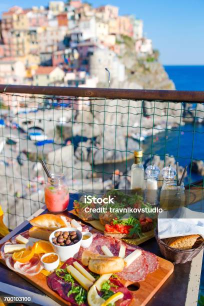 Tasty Italian Snacks Fresh Bruschettes Cheeses And Meat On The Board In Outdoor Cafe With Amazing View In Manarola Italy Stock Photo - Download Image Now