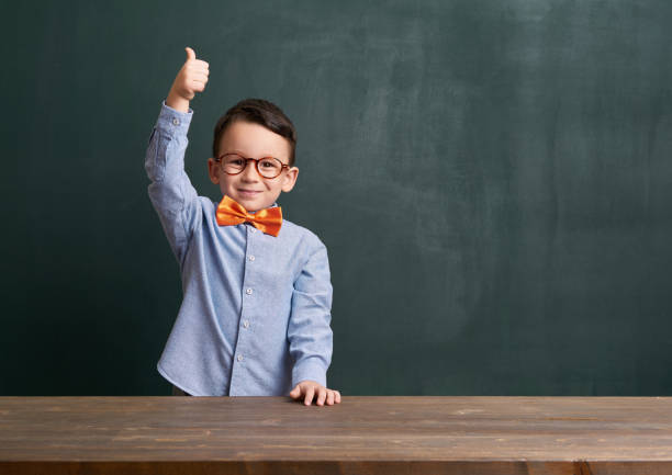 istock Cute child is in front of chalkboard 700105240