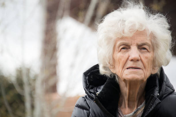 istock Senior Woman Outdoors Lost in Thoughts 700109410