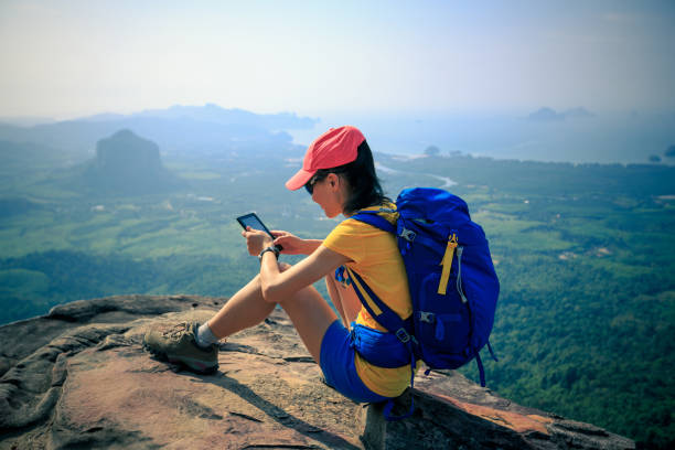 istock successful woman hiker reading e-book on mountain top 700109566