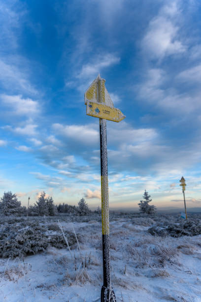 signpost on a mountain top, showing the way to the nearest shelter