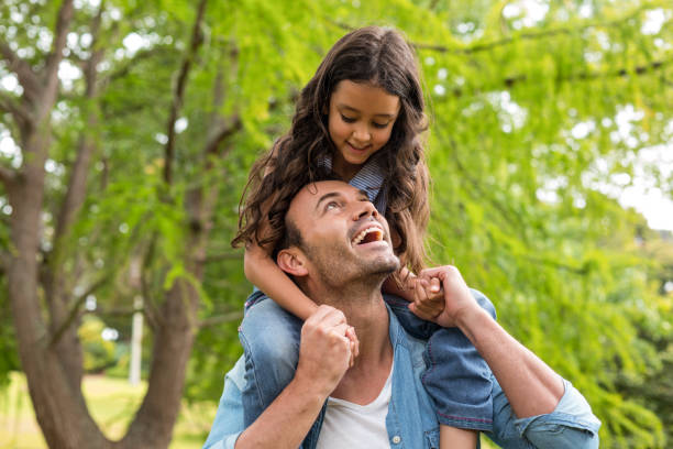 istock Father carrying daughter on his shoulders 700119216